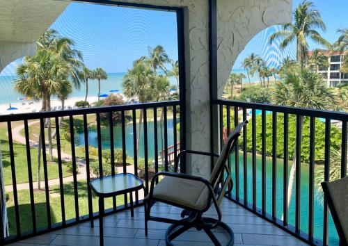 a balcony with a chair and a view of the beach at Sanibel Sunset Where the Sun Meets the Sea in Sanibel