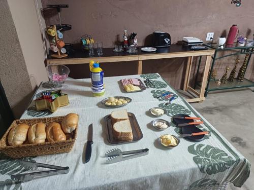 a table with bread and a basket of food on it at Pousada Escape Jungle in Bragança Paulista
