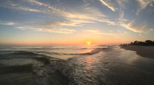 a sunset on a beach with the ocean at Sanibel Sunset Where the Sun Meets the Sea in Sanibel