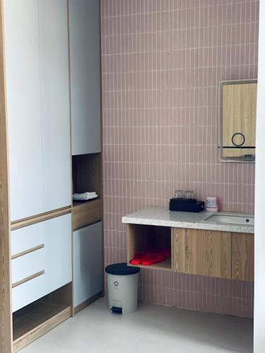 a bathroom with a counter and a pink tiled wall at Homestay 1986 & Homestay Vinhomes Vu Yen, Hai Phong City 