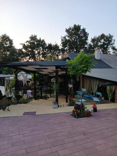 a building with a blue roof and a patio at Smestaj sa bazenom Sunny Hill in Smederevska Palanka