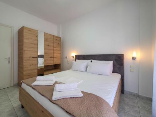 a bedroom with a large bed with two towels on it at ARETI Suites by SDR in Olympiaki Akti