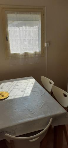 une pièce avec une table et deux chaises et une fenêtre dans l'établissement P2 35m2 LeGrau du Roi, au Grau-du-Roi