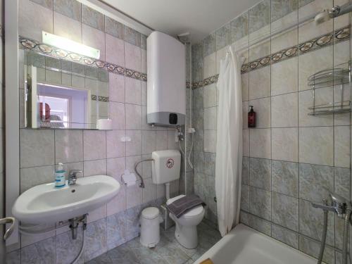 a bathroom with a sink and a toilet at ARETI Suites by SDR in Olympiaki Akti