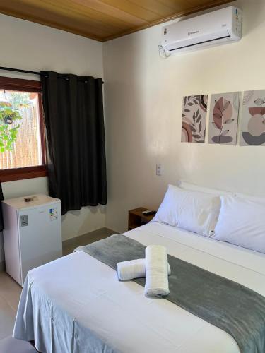 a bedroom with two beds and a window at Vale dos Cristais Suítes in Alto Paraíso de Goiás