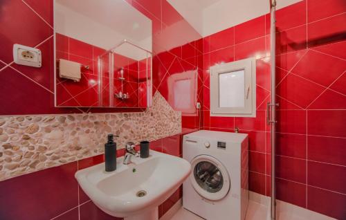 a red bathroom with a sink and a washing machine at Apartman Cukar Pula in Pula