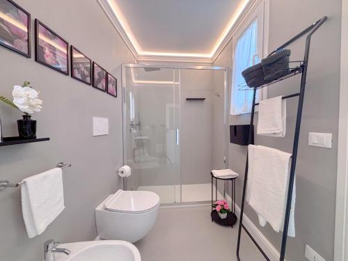 a white bathroom with a toilet and a shower at Luxury Suite - Free WifI - Smart Tv - centro Storico in Mesagne