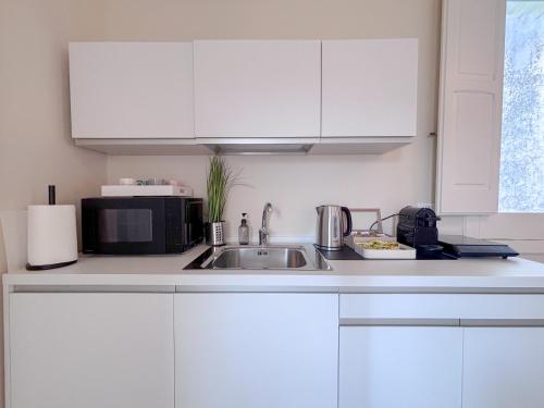 a white kitchen with a sink and a microwave at Luxury Suite - Free WifI - Smart Tv - centro Storico in Mesagne