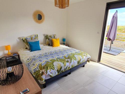 une chambre avec un lit avec des oreillers colorés dessus dans l'établissement T2 Yucca LCP - Beautiful 48 m2 2-room, 17 m2 terrace, new, air conditioning, à Grosseto-Prugna