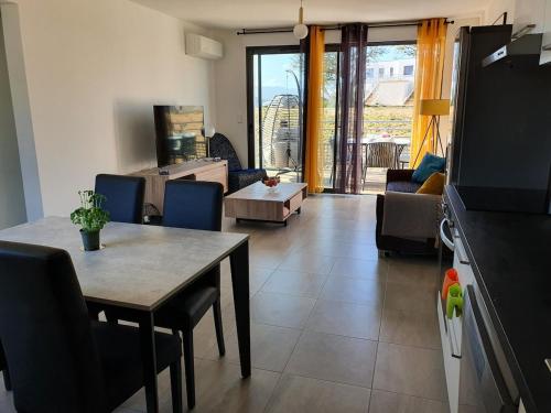 un salon avec une table et un canapé dans l'établissement T2 Yucca LCP - Beautiful 48 m2 2-room, 17 m2 terrace, new, air conditioning, à Grosseto-Prugna