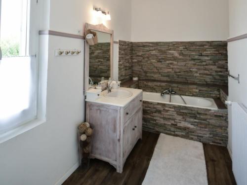 a bathroom with a sink and a tub and a mirror at Le Petit Domaine de Colayrac in Colayrac-Saint-Cirq