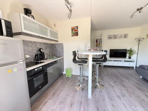 une cuisine avec une table et quelques chaises dans l'établissement Charmant T2 à 2 min de la mer, avec Jardin Privé et clôturé, Parking, à proximité du Centre-Ville, à Cabourg