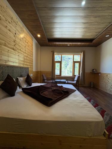 a large bed in a room with a wooden ceiling at Sun Beam Hotel Koksar in Khoksar