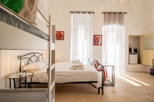 a bedroom with a bunk bed and a table and chairs at Cortile Carducci in Racale