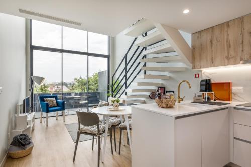 a kitchen and dining room with a spiral staircase at Douro Tower Loft - Shared Pool in Vila Nova de Gaia