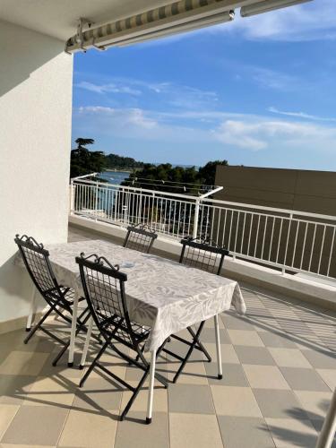 a balcony with a table and chairs on a roof at Apartments Villa More in Makarska