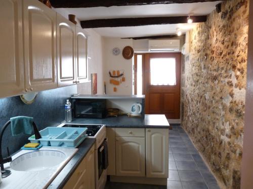 une cuisine avec un évier et un plan de travail dans l'établissement Maison de charme - proche toutes commodités, à Marseillan