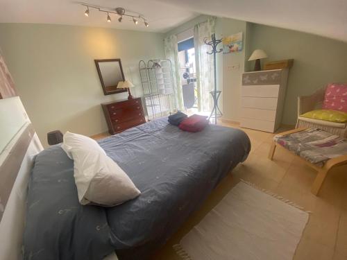 Un dormitorio con una gran cama azul con almohadas. en Ático en Riaza con todas las comodidades, en Riaza