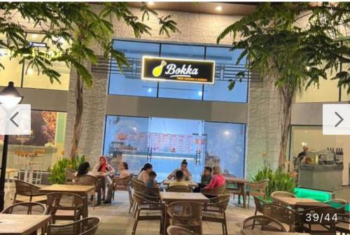 un grupo de personas sentadas en mesas en un restaurante en Aqua view resort studio, en El Qasaba esh Sharqīya