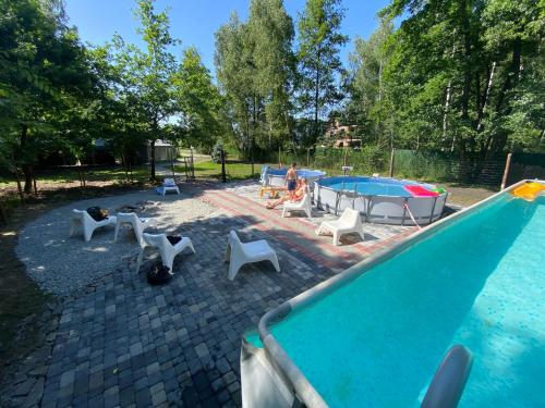 a pool with a group of chairs and a pool table at Apartament Nad Stawem in Wadowice