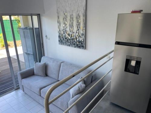 - un salon avec un canapé et un réfrigérateur dans l'établissement Appart rez de chaussée avec terrasse, proche plage, parking - FR-1-749-93, au Cap d'Agde