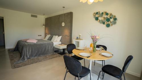 una camera da letto con un letto, un tavolo e delle sedie di Les Villas du Parc de la Chabotterie a Saint-Sulpice-le-Verdon