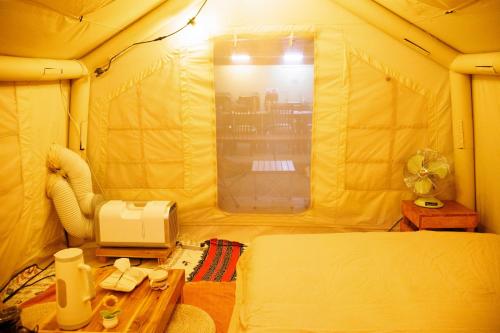 a room with a bed and a microwave in a tent at October Hostel ChiangMai in Chiang Mai