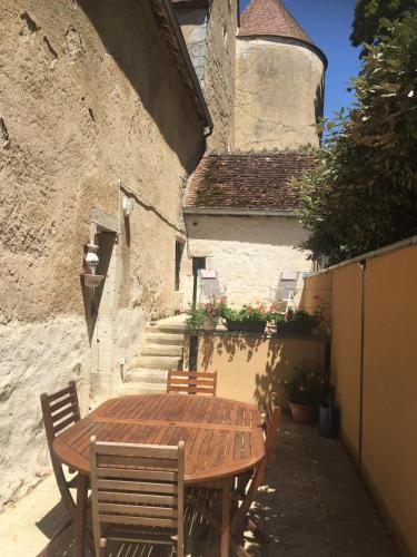une table et des chaises en bois installées à côté d'un bâtiment dans l'établissement Logement Château de Villeneuve, 