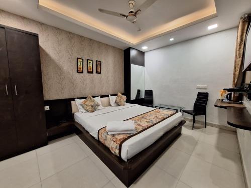 a bedroom with a large bed and a chair at Hotel Mayur Palace in Bhopal