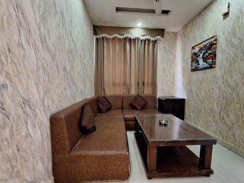 a living room with a brown couch and a table at Hotel Mayur Palace in Bhopal