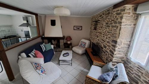 - un salon avec deux canapés et un mur en pierre dans l'établissement Maison Bretonne, à La Boussac