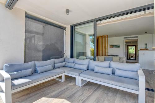 a living room with a blue couch and a large window at Luxury Central Apartments, Illa Blanca, Calella in Calella de Palafrugell