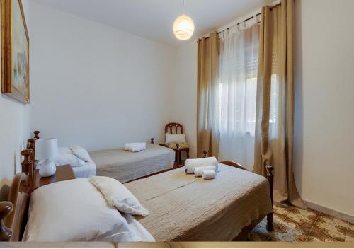a bedroom with two beds and a window at Appartamento casa vostra in Bosa