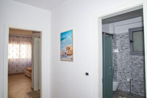 ein Zimmer mit einer weißen Wand und einem Badezimmer in der Unterkunft Seashell Apartment in Vlorë