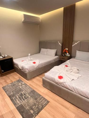 two beds in a room with red flowers on them at Mena Pyramids Hotel in Cairo