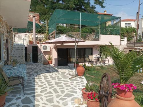 a patio with potted plants and an umbrella at The cave of Cyclops in Mákri