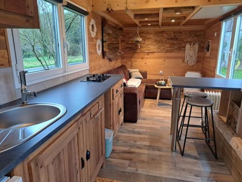 Les RosiersにあるSIMPLES ESCALES nuit en Tiny Houseのシンク付きのキッチンとリビングルーム