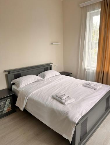 a bedroom with a large bed with two towels on it at villa gardens in K'obulet'i