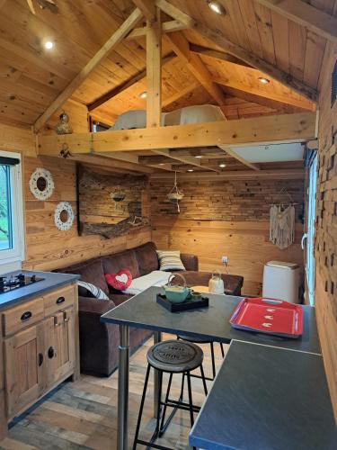 une cuisine et un salon dans une cabane en rondins dans l'établissement SIMPLES ESCALES nuit en Tiny House, à Les Rosiers
