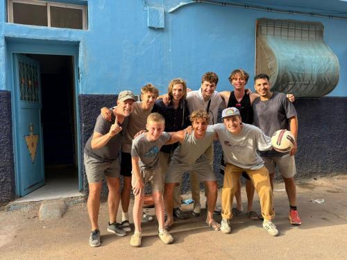 a group of men posing for a picture in front of a blue building at Moroccan Family House in Agadir
