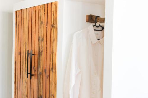 a white shirt on a hanger next to a door at Hartshuijs in Beaufort West