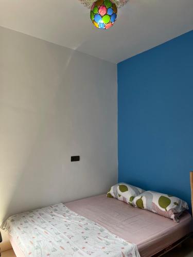 a bedroom with a bed and a blue wall at Moroccan Family House in Agadir