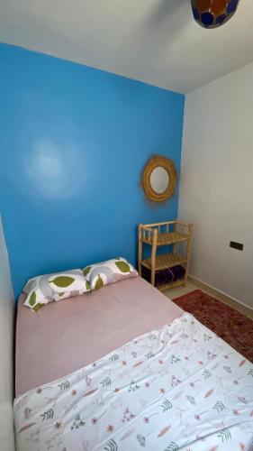 a bedroom with a bed with a blue wall at Moroccan Family House in Agadir