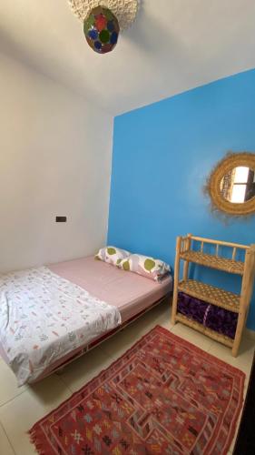 a bedroom with a bed and a mirror and a rug at Moroccan Family House in Agadir