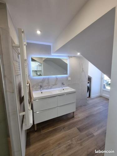 une salle de bain blanche avec un lavabo et un miroir dans l'établissement Luminous and elegant 3BR apartment in hyper centre, à Pau