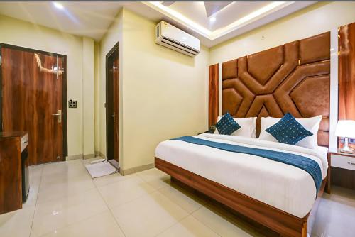 a bedroom with a large bed with a wooden headboard at Family stay Prem Dlx Hotel -3'Minutes WalkFrom NDLS Railway Station in Jāmb