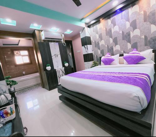 a bedroom with a large bed with purple pillows at Family stay Prem Dlx Hotel -3'Minutes WalkFrom NDLS Railway Station in Jāmb