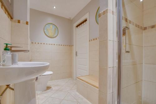 une salle de bain avec un lavabo, des toilettes et une douche dans l'établissement Spacious & Stylish 5BR Townhouse - Free Parking, à Manor
