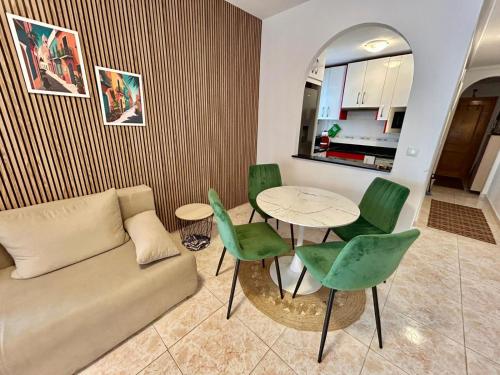 una sala de estar con un sofá, una mesa y sillas en Hola Torrevieja, en Torrevieja