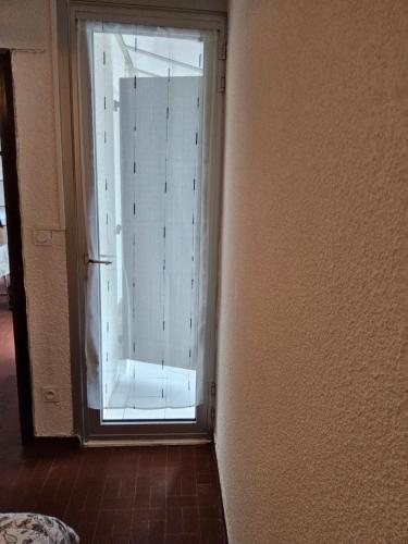 une porte menant à une chambre avec une porte coulissante en verre. dans l'établissement Le Cardinale in Barcarès Beach 4 people, au Barcarès